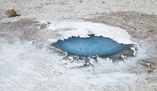 Eine heiße Quelle inmitten von Sinterablagerungen. Die intensivblaue Farbe lässt auf kieselsäurehaltiges Wasser schließen.