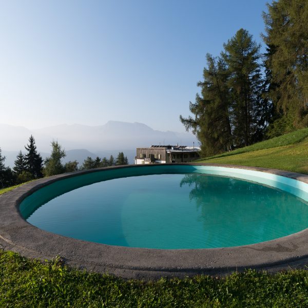 Türkiser Pool, dahinter die Pension Briol